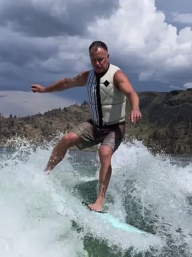 Patrick Hall wake surfing on a lake