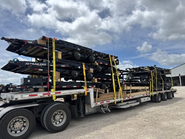 Stacked utility trailers loaded on a step deck